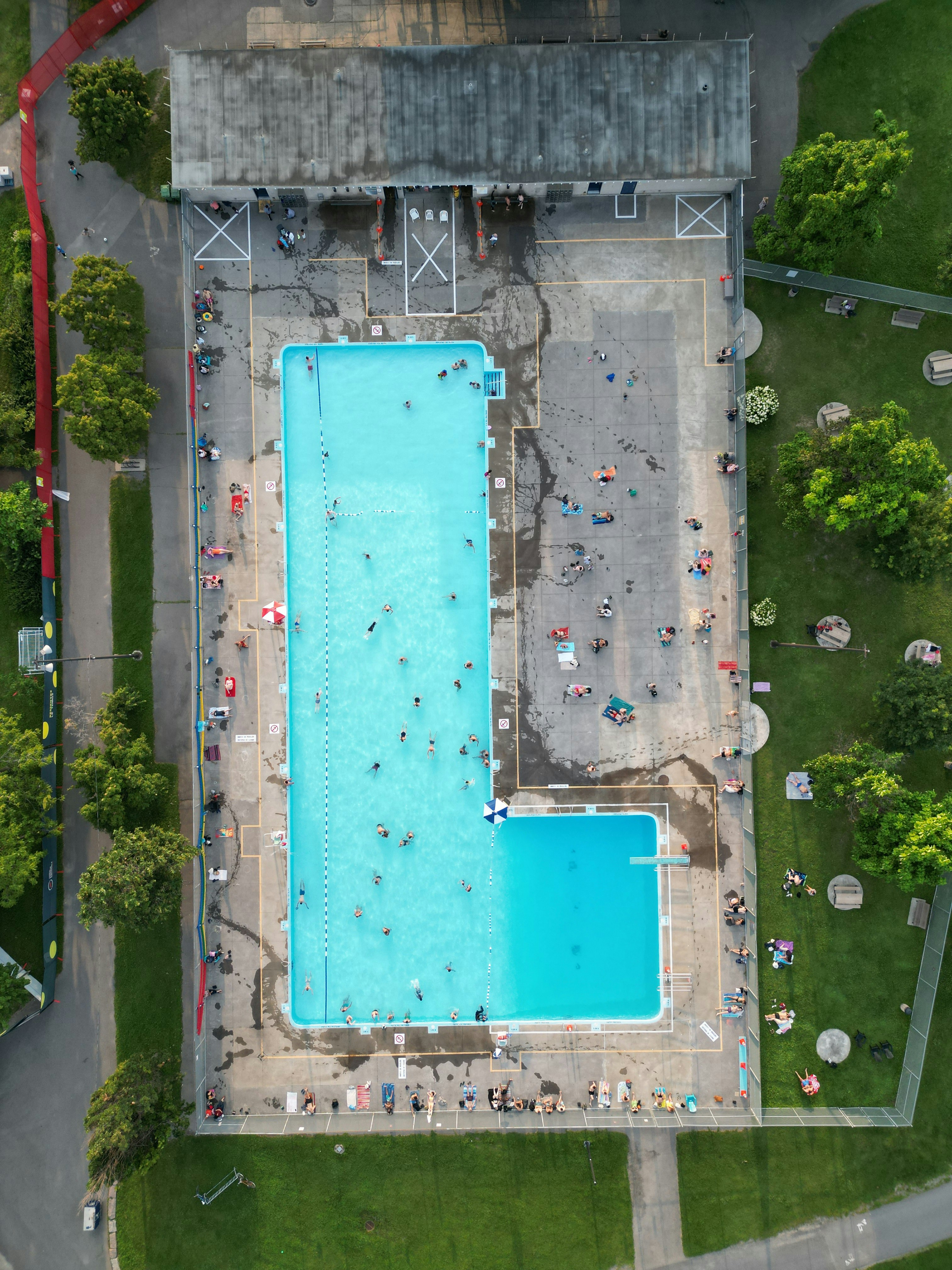 Gente nadando y relajándose en un gran complejo de piscinas públicas.