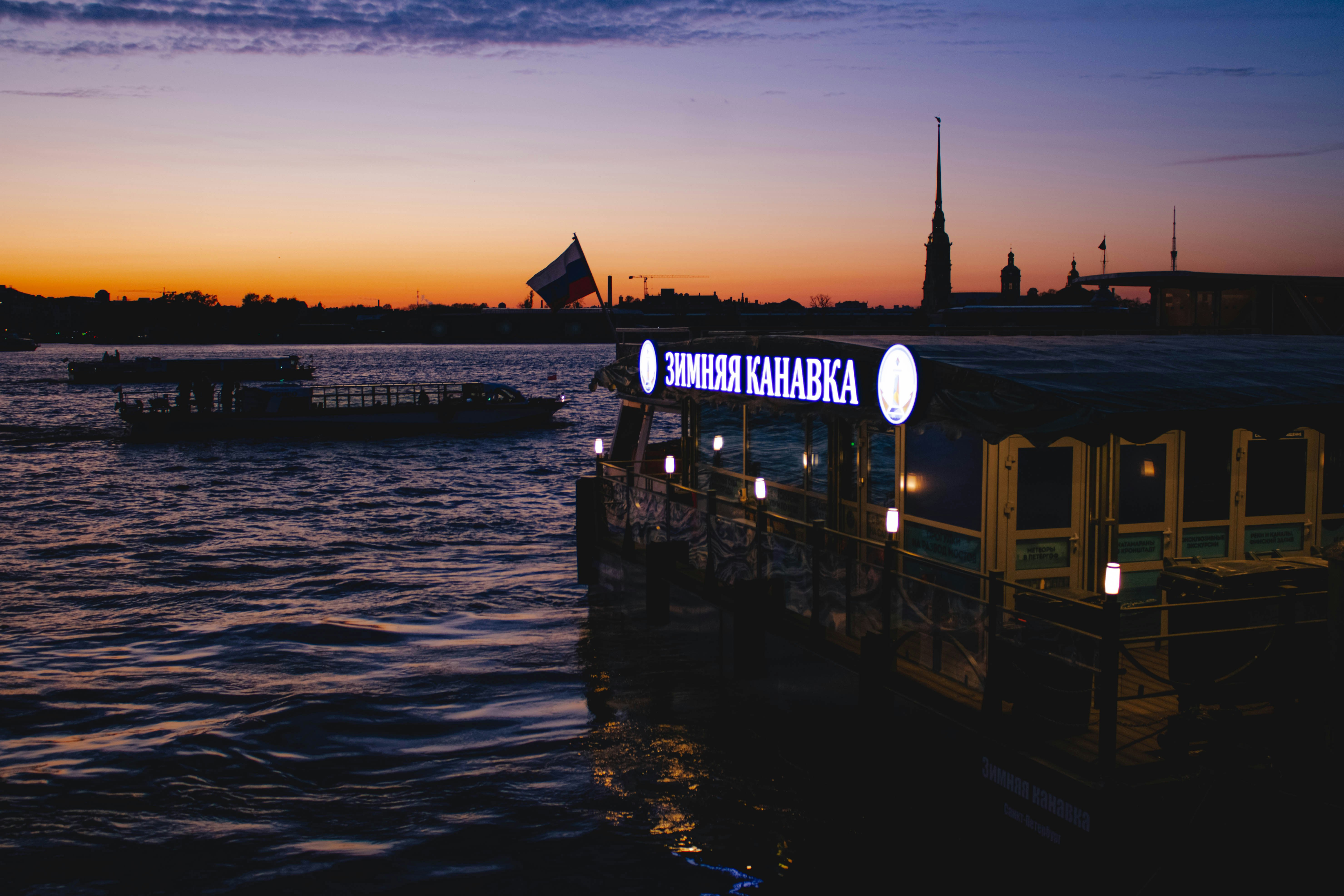 Boats float on water as the sun sets.