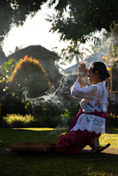 Woman in prayer, with incense smoke.