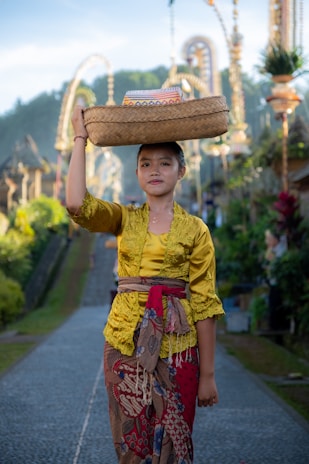 Young Balinese dancer in traditional golden attire. Represents cultural life with a Bali visa.