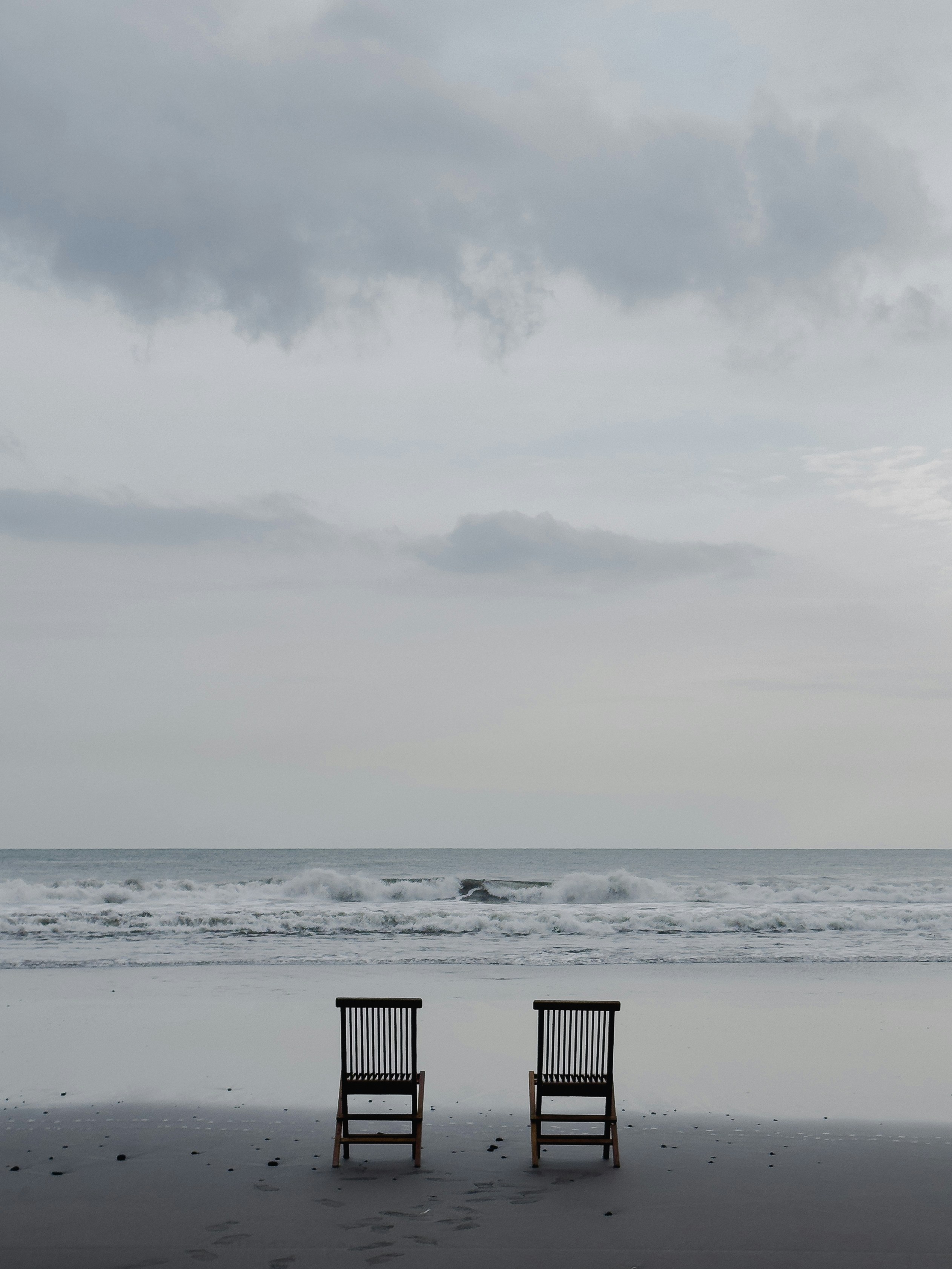 Deux chaises sont assises sur la plage au crépuscule