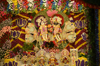 Krishna and radha idols, decorated with flowers.
