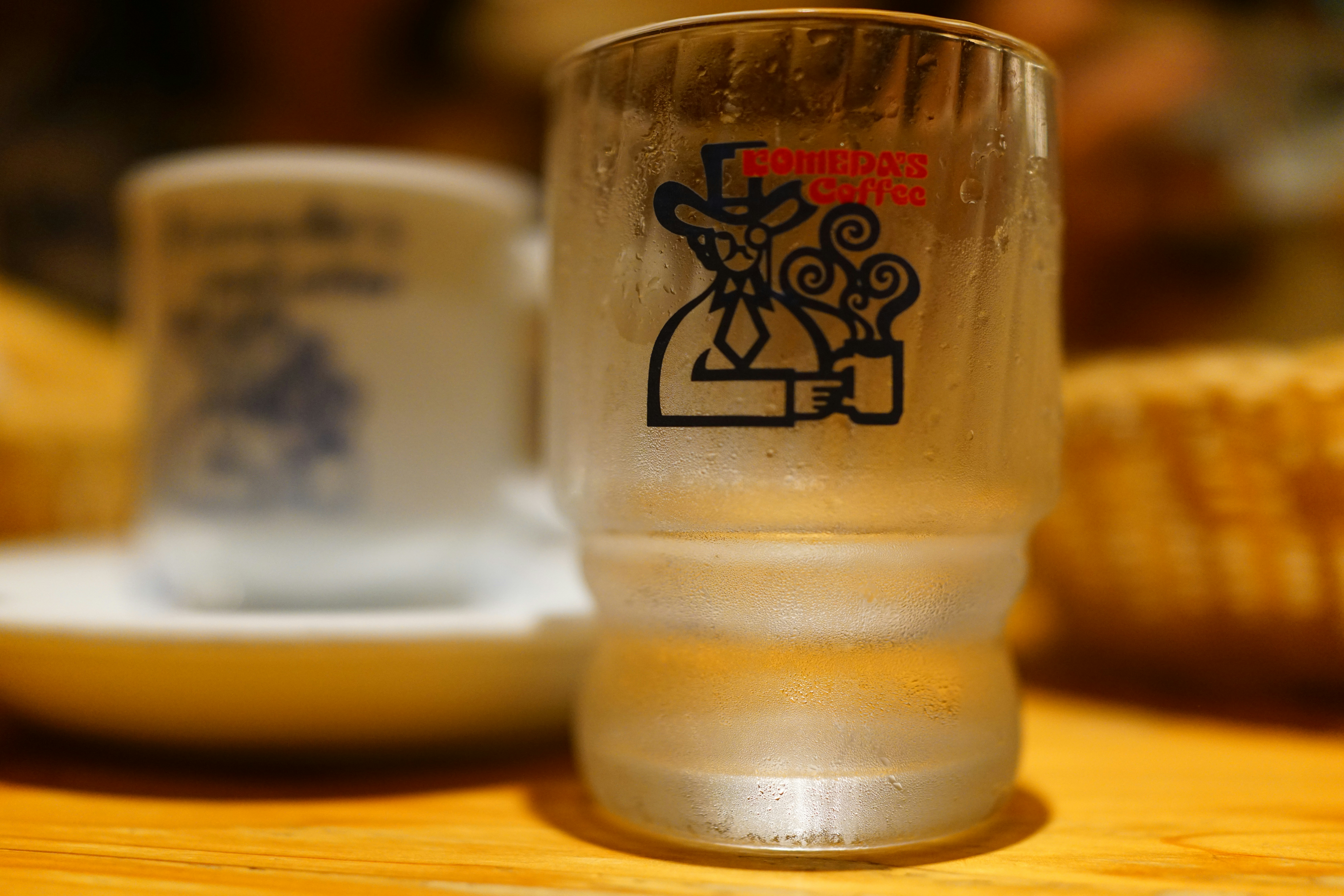 Japanese person politely pouring sake for a colleague at a dinner table, hands on bottle and glass