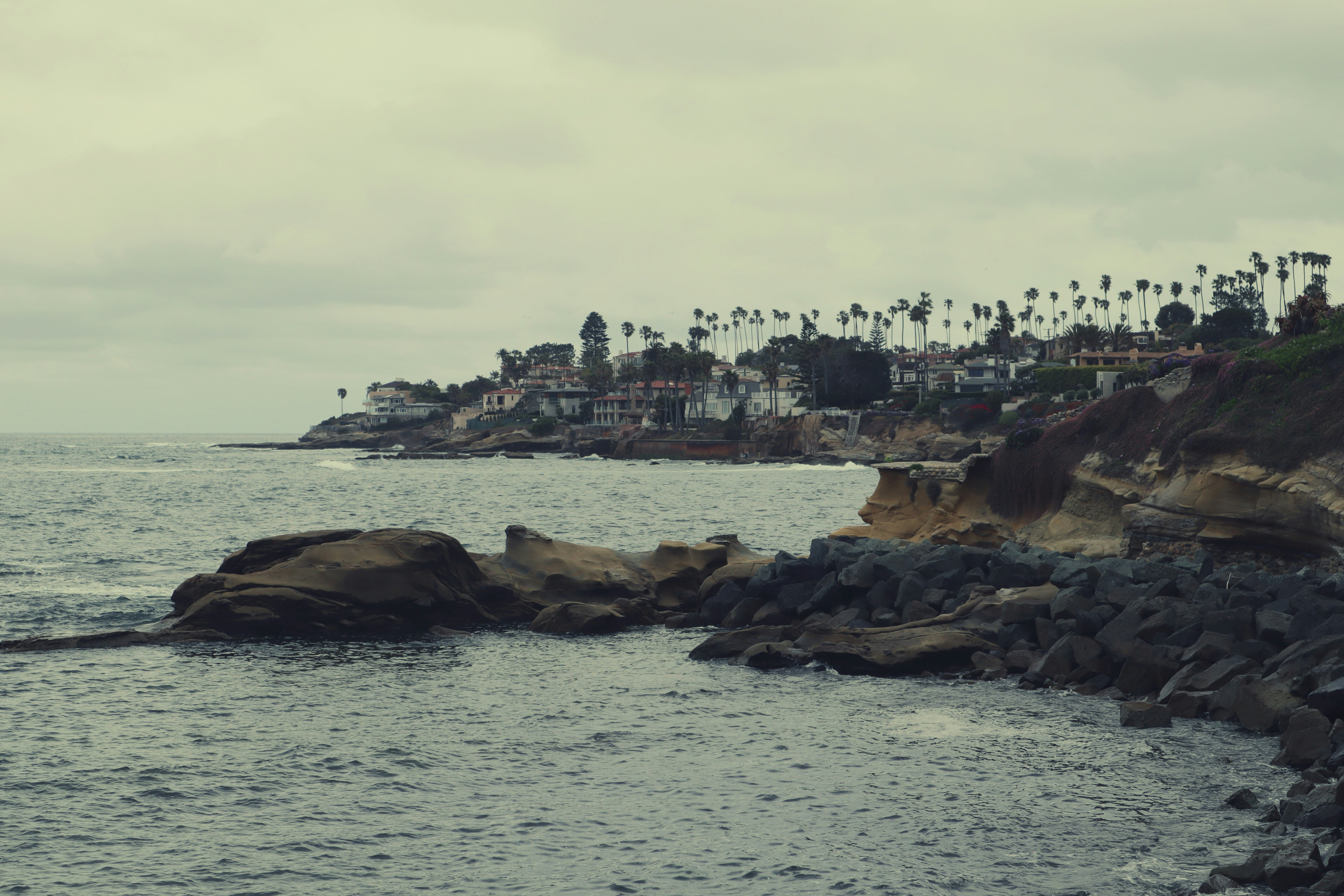 Coastal town on a cloudy day with rocky coast.