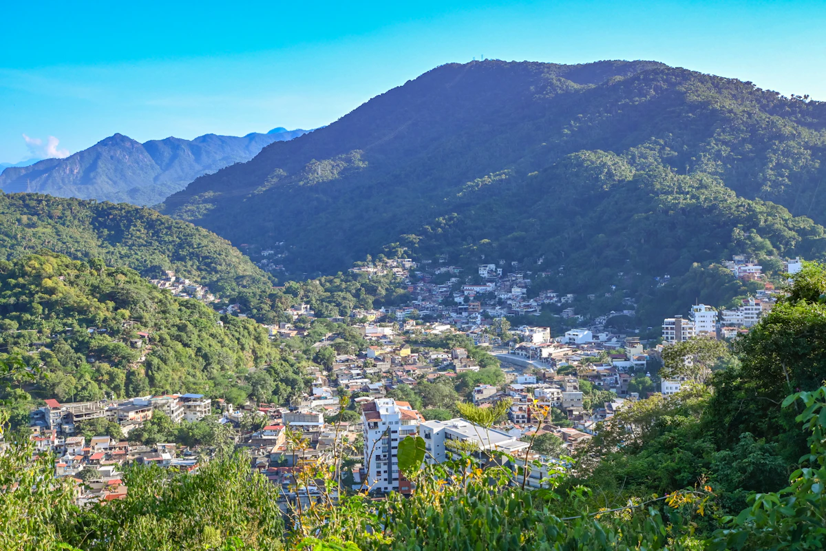 Houses spread through a green valley in Puerto Vallarta, under steep forested mountains