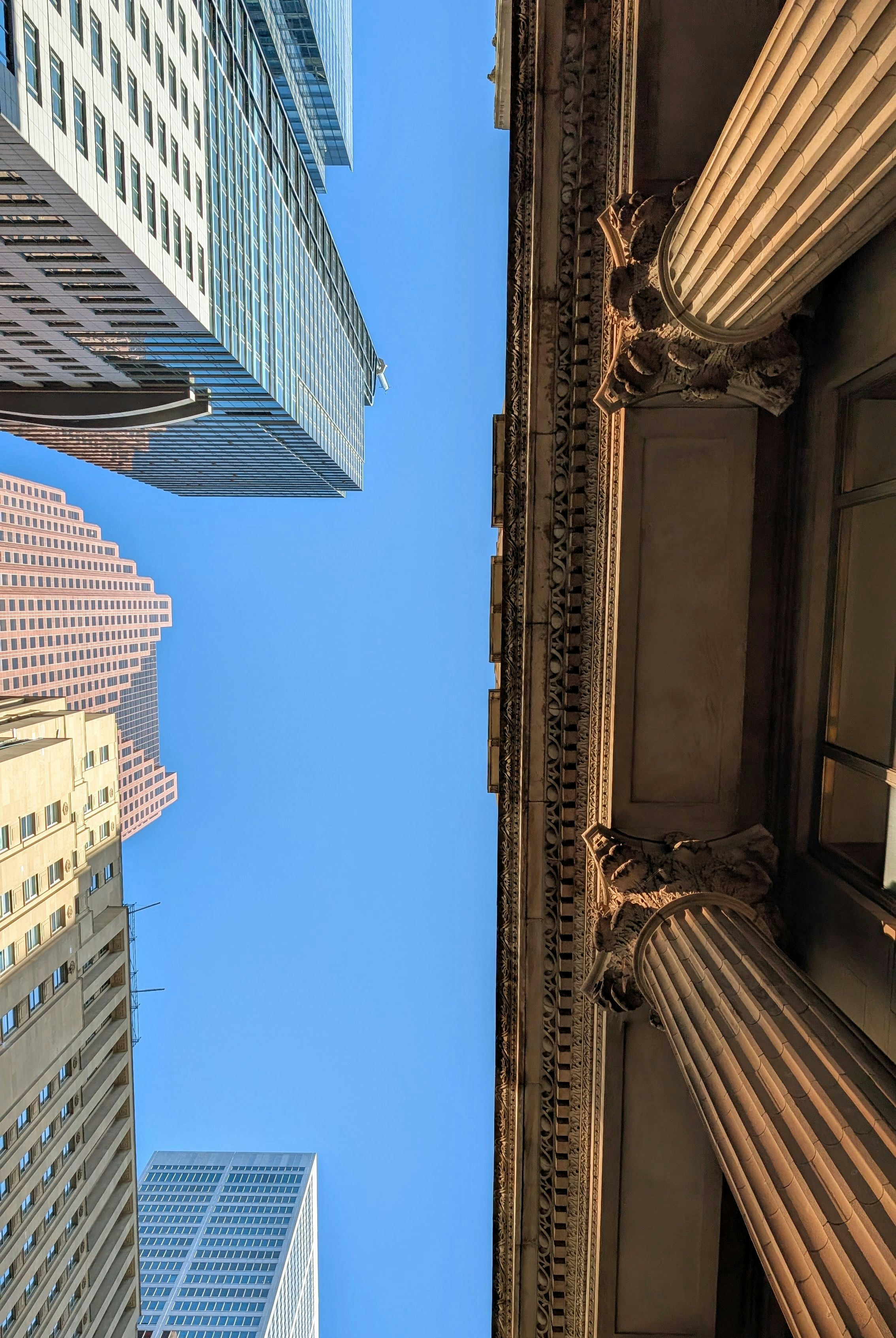 Skyscrapers and columns reach towards a blue sky. photo – Free Building ...