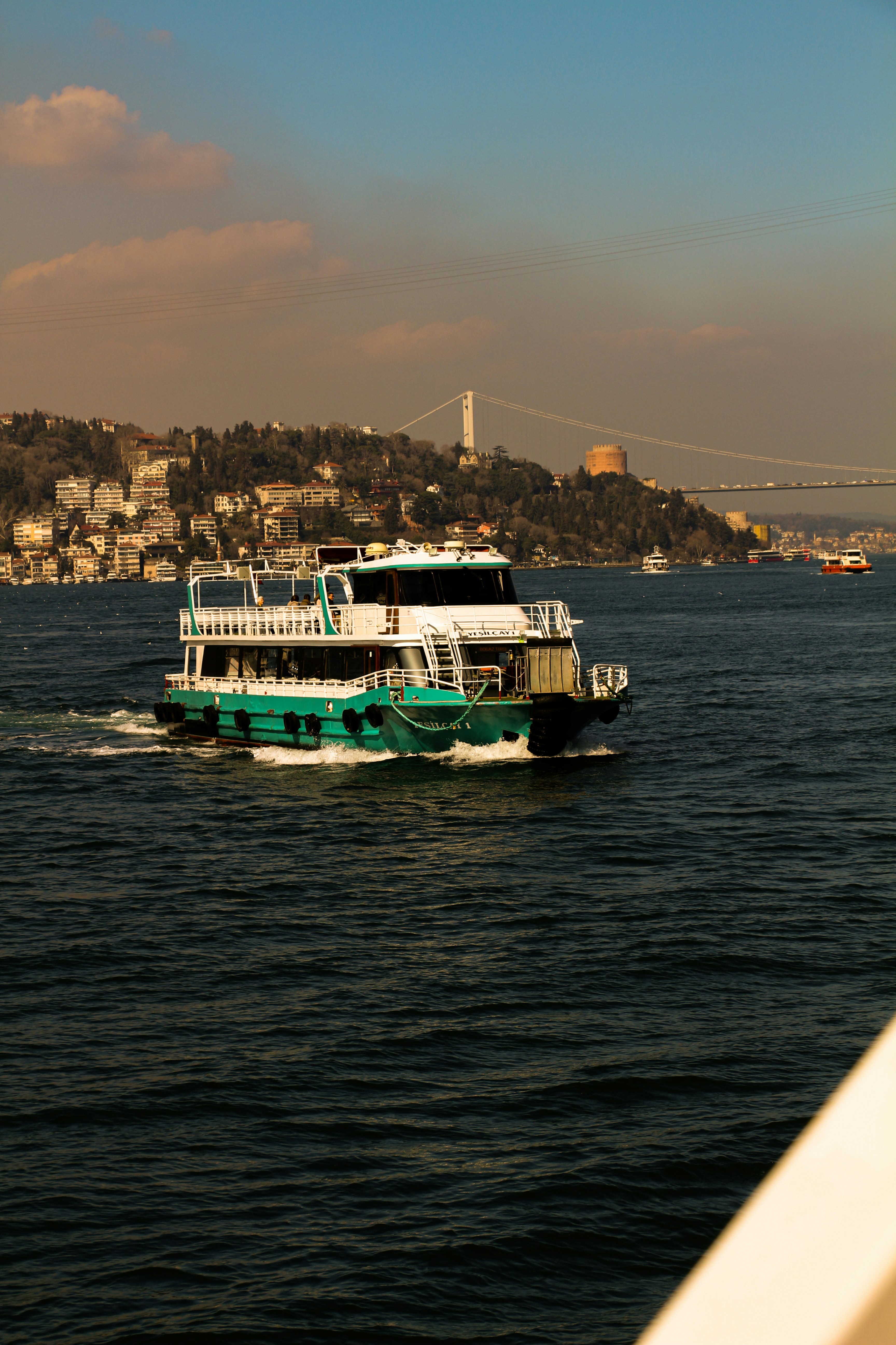A ferry boat sails in the water near a city.