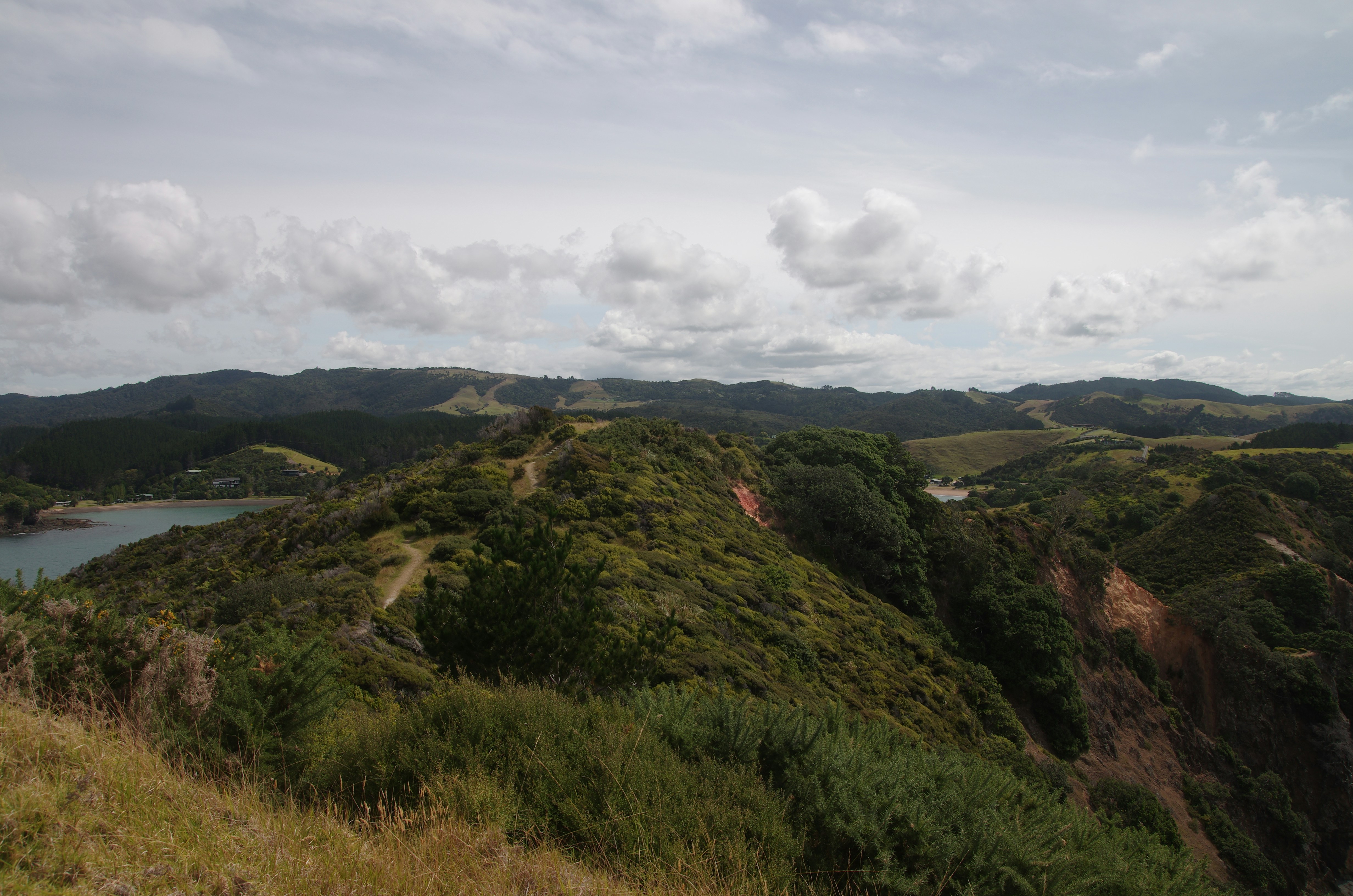 Rolling hills and green terrain under a cloudy sky.