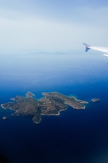 Airplane view of an island surrounded by ocean.