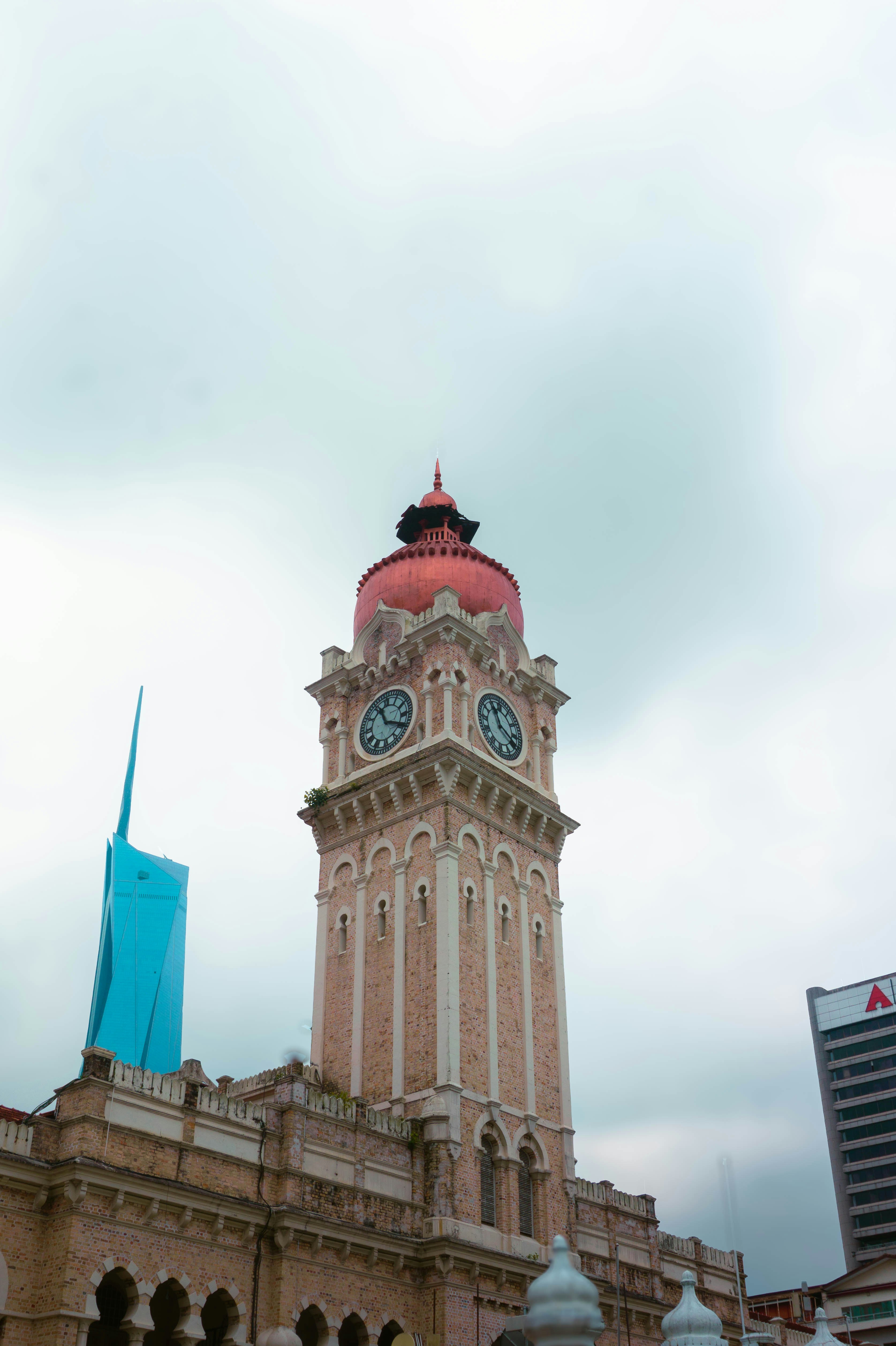 A tall clock tower stands beneath a cloudy sky.