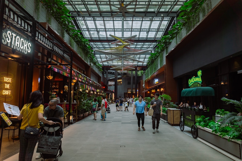 A modern mall with shops and people walking.