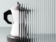 A coffee maker's reflection through a textured surface.