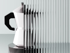 A coffee maker's reflection through a textured surface.