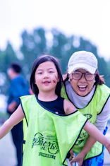 A girl and woman smile after an outdoor activity.