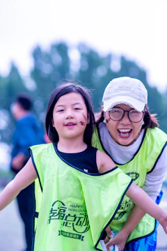A girl and woman smile after an outdoor activity.