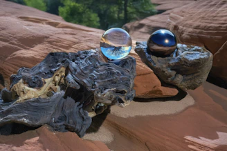 Crystal balls rest on rocks in a natural setting.