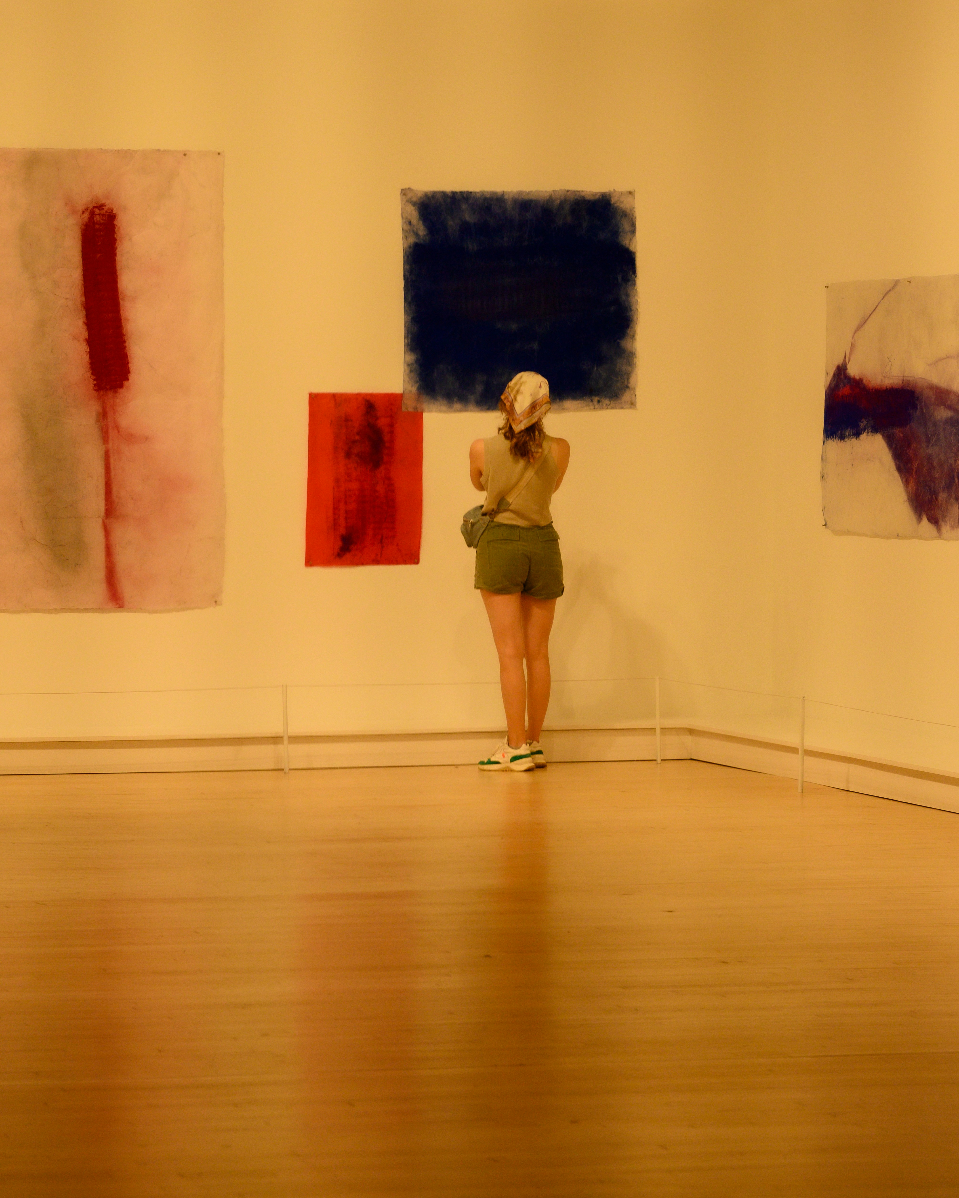A woman looks at abstract art in a gallery.