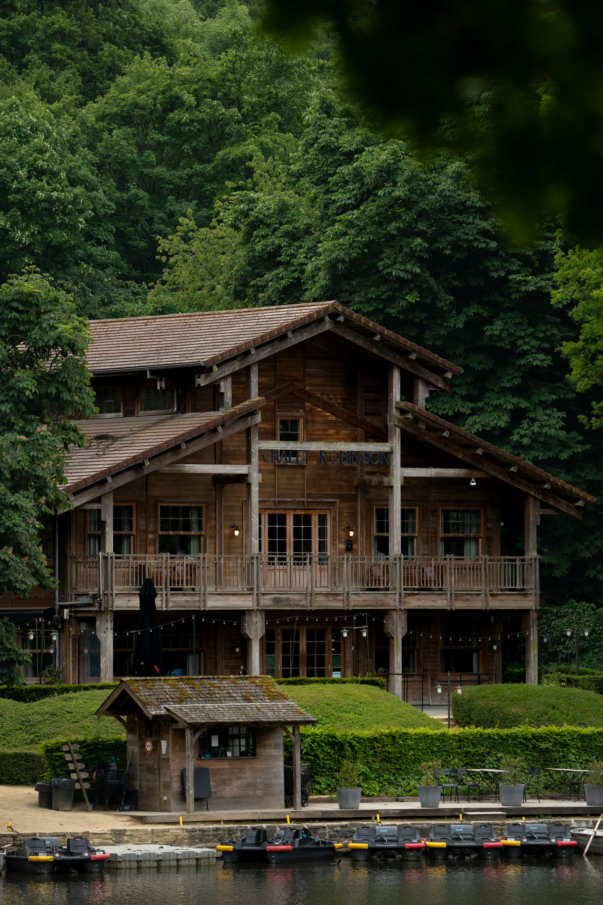 Wooden house nestled amongst lush green trees.
