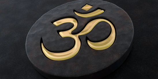 A golden om symbol on a dark stone.