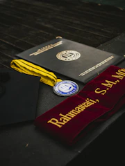 Graduation diploma, medal, and sash displayed.