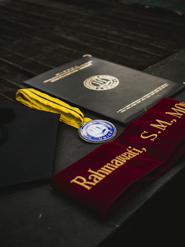 Graduation diploma, medal, and sash displayed.