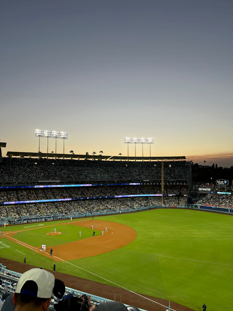 Baseball game in progress at a stadium during dusk