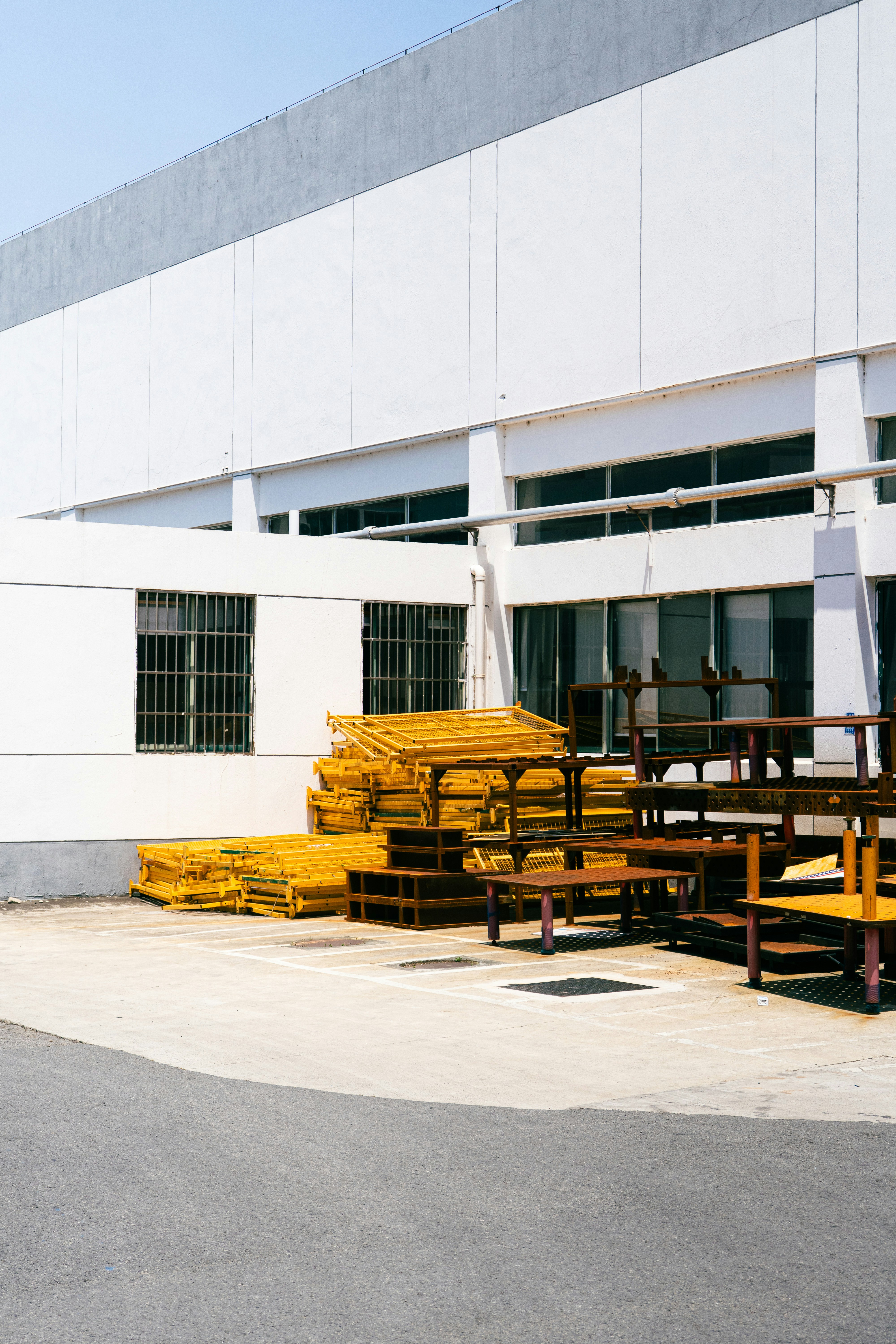 Yellow scaffolding and wooden benches are outside a building.