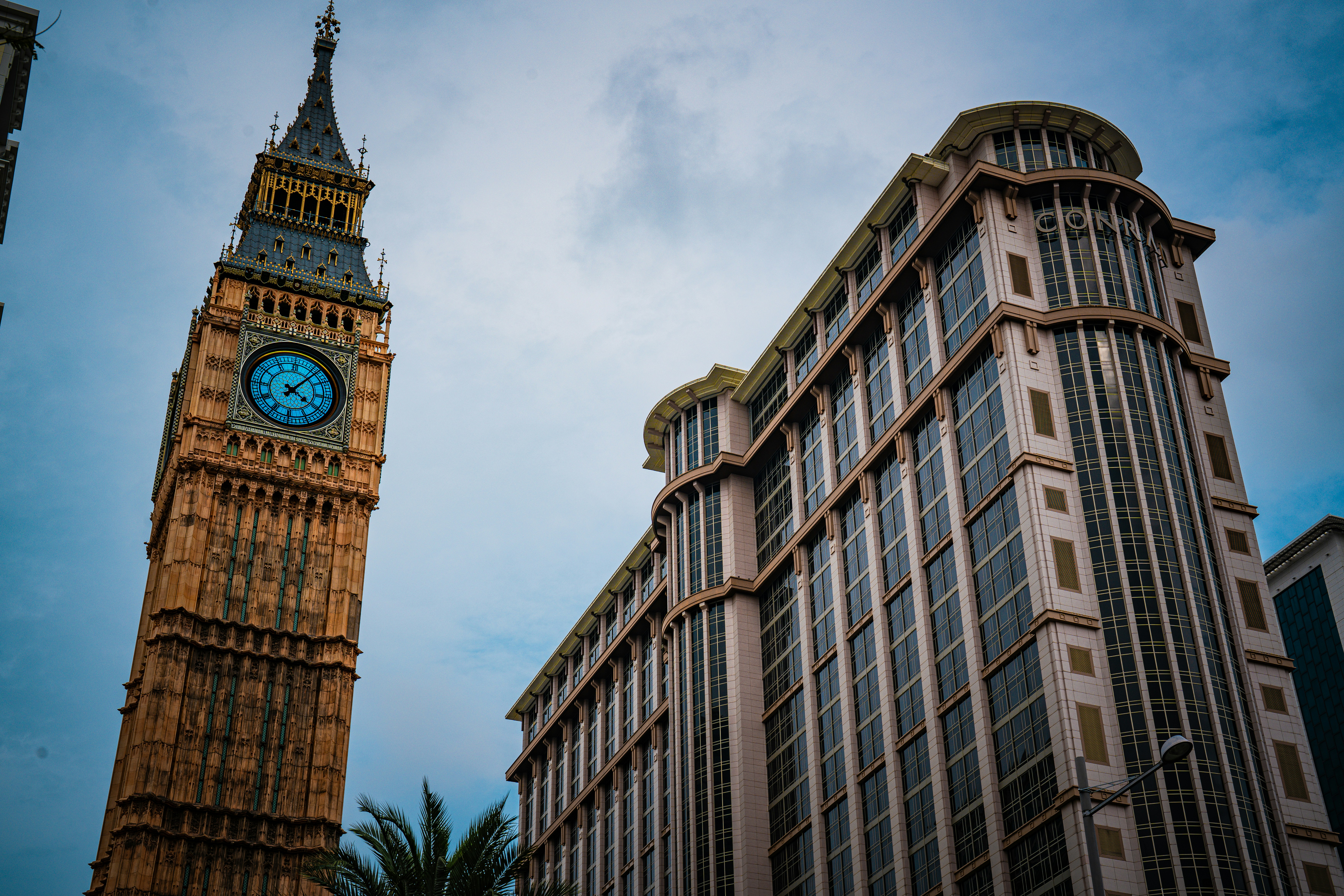 Der Big Ben Tower steht neben einem großen Gebäude.
