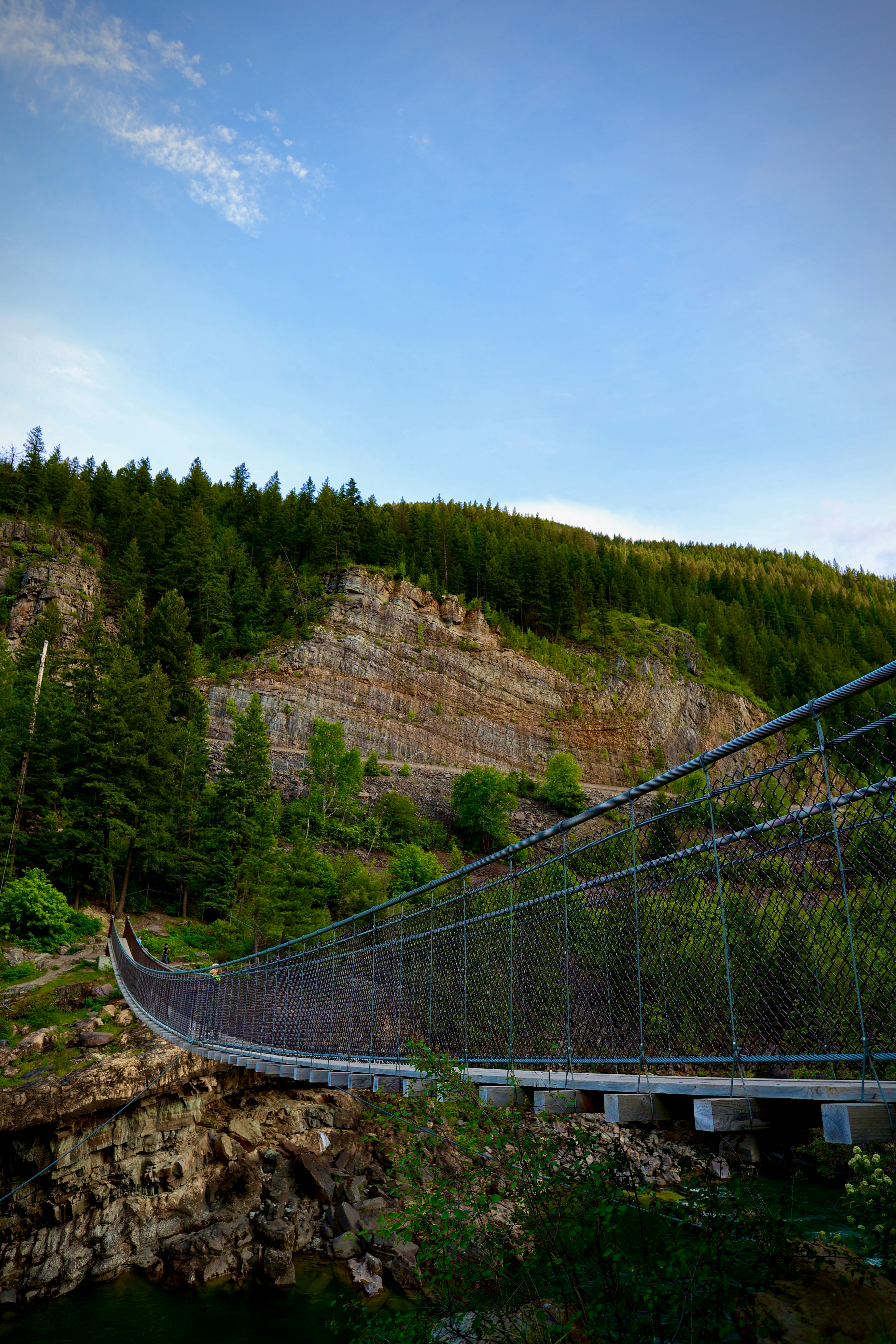 A suspension bridge spans over a rocky cliff.