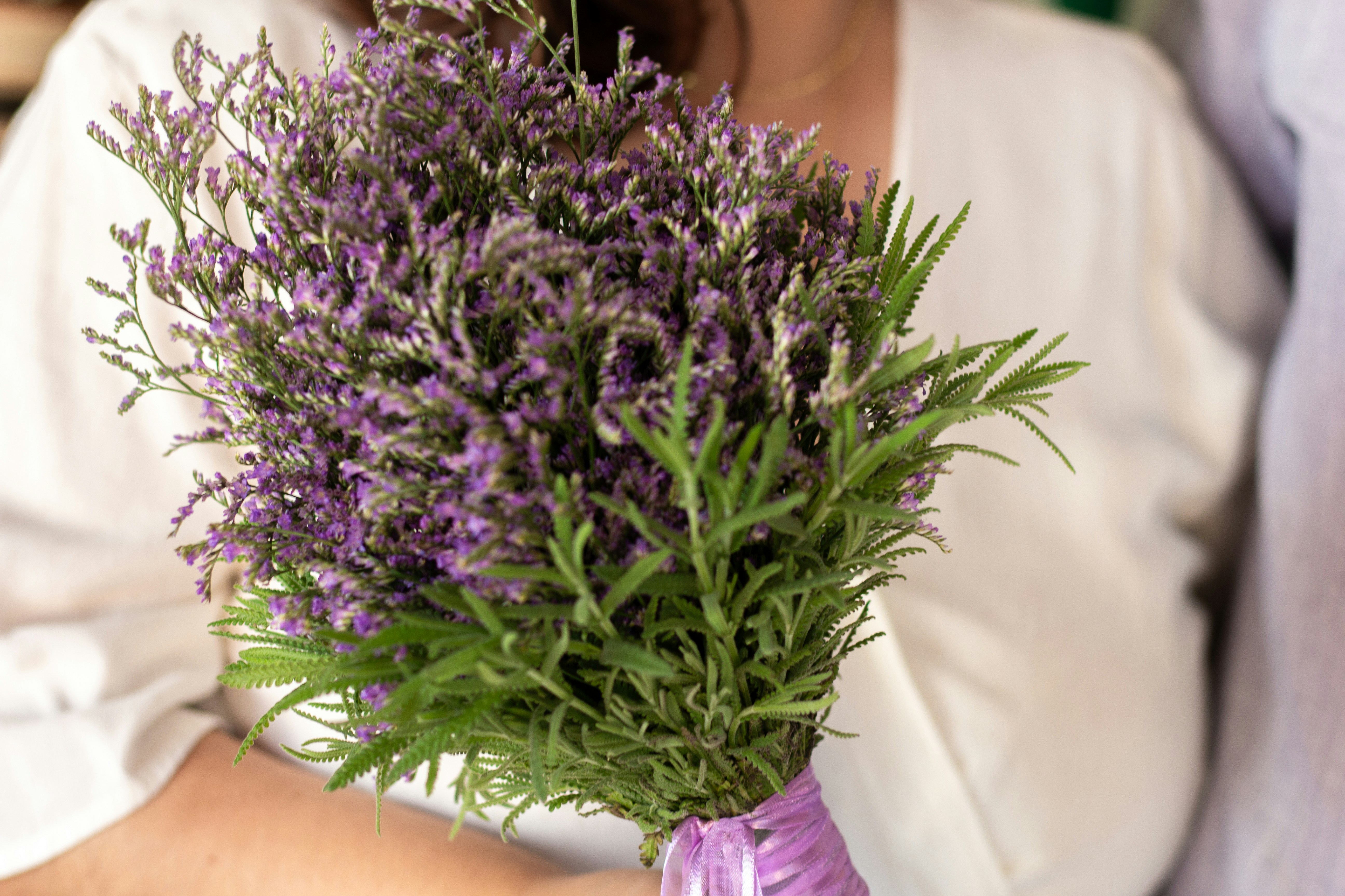 A beautiful bouquet of purple flowers is being held.