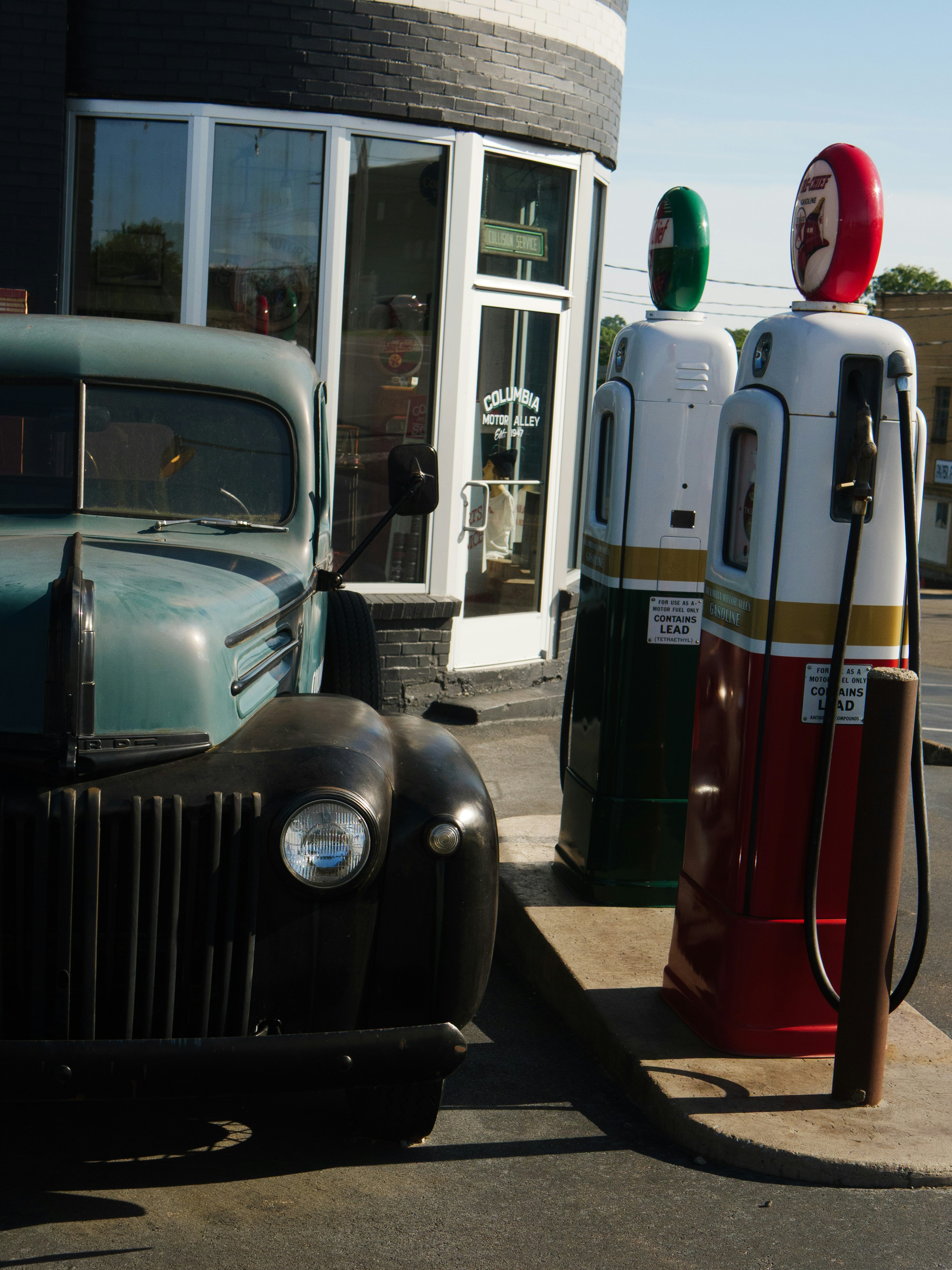 Vintage truck and gas pumps at a store.