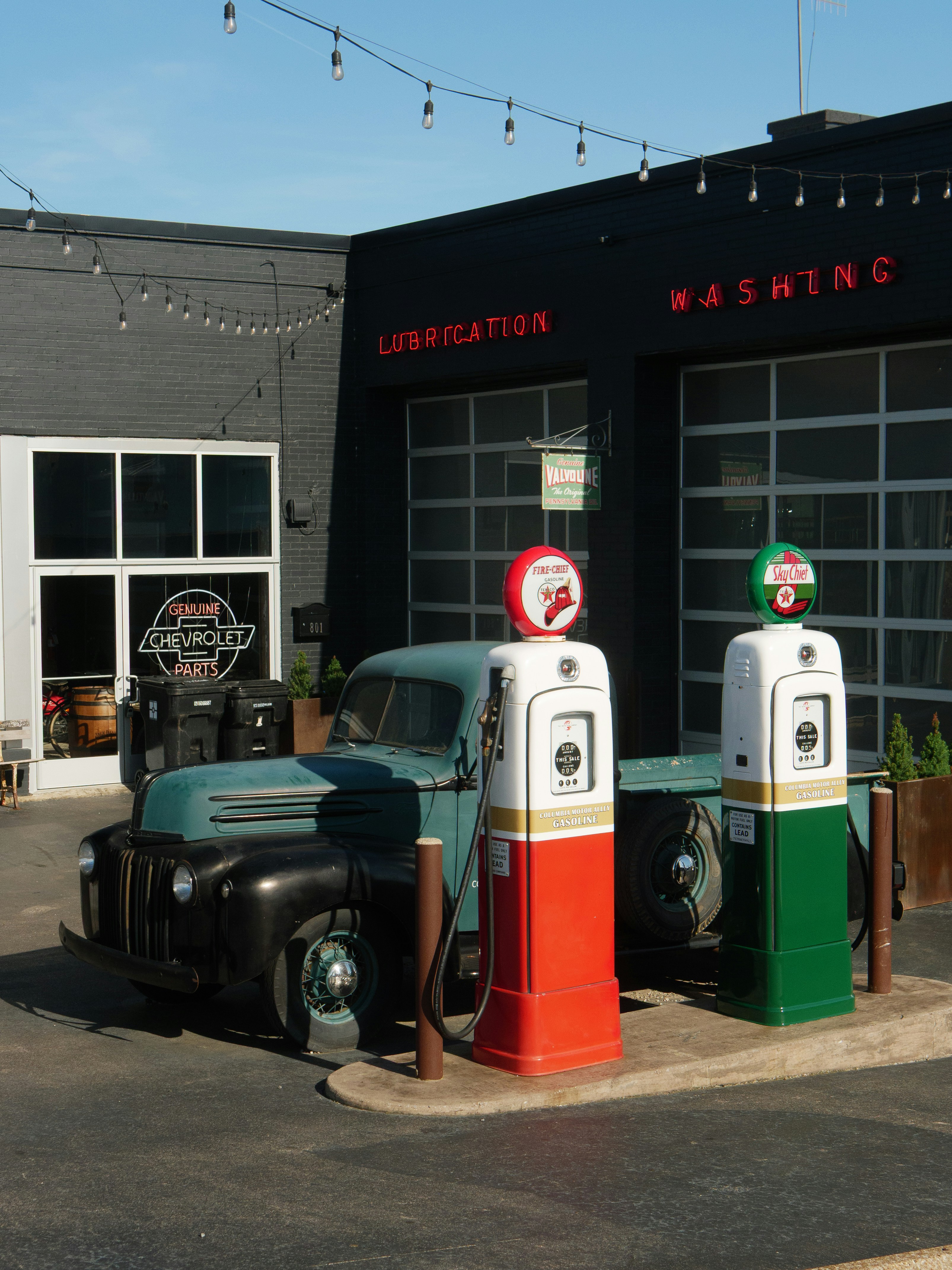 Vintage truck parked by old gas pumps.