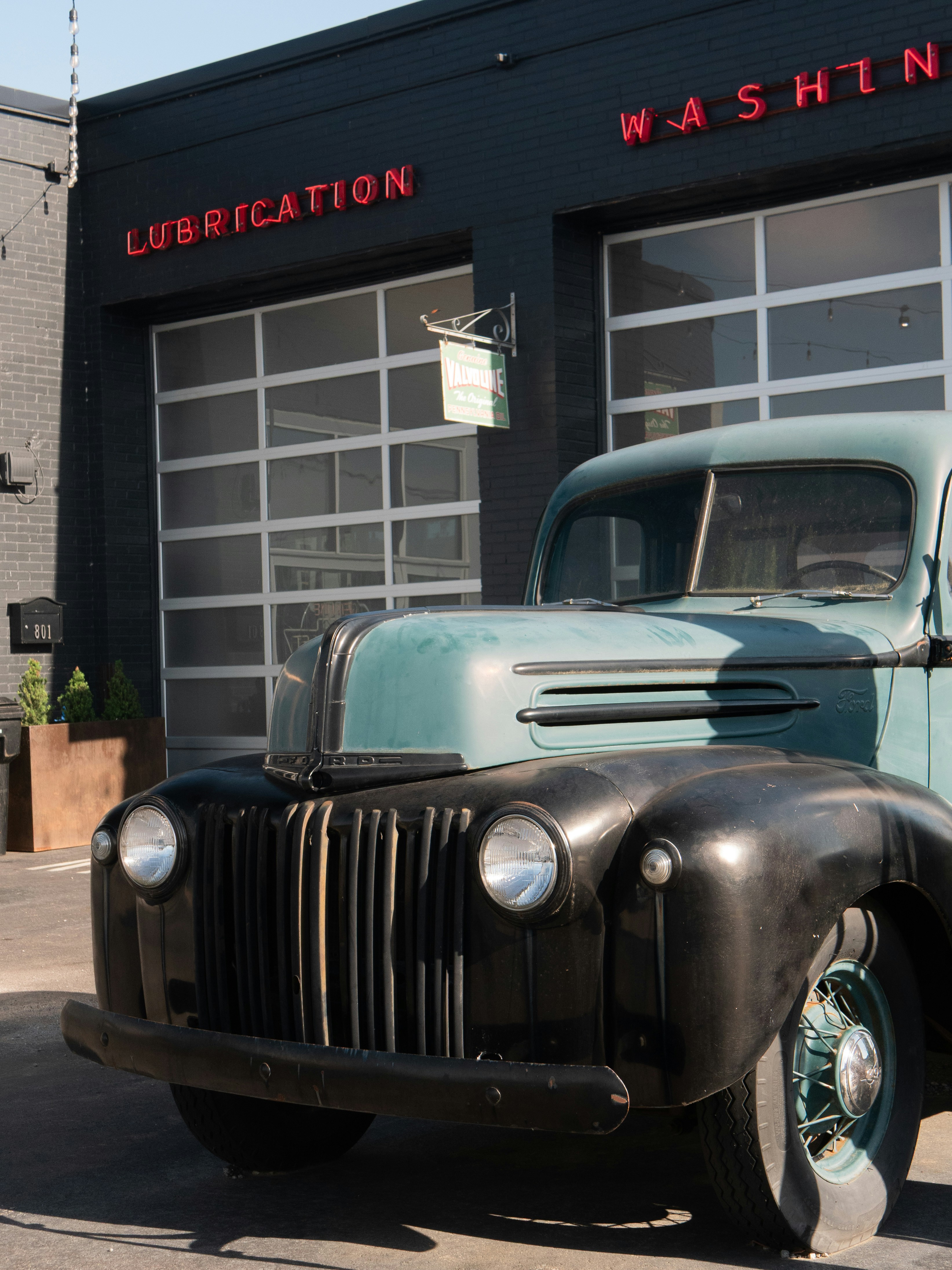 Classic truck in front of a vintage auto shop.