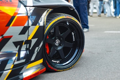 A race car's wheel with a black rim.