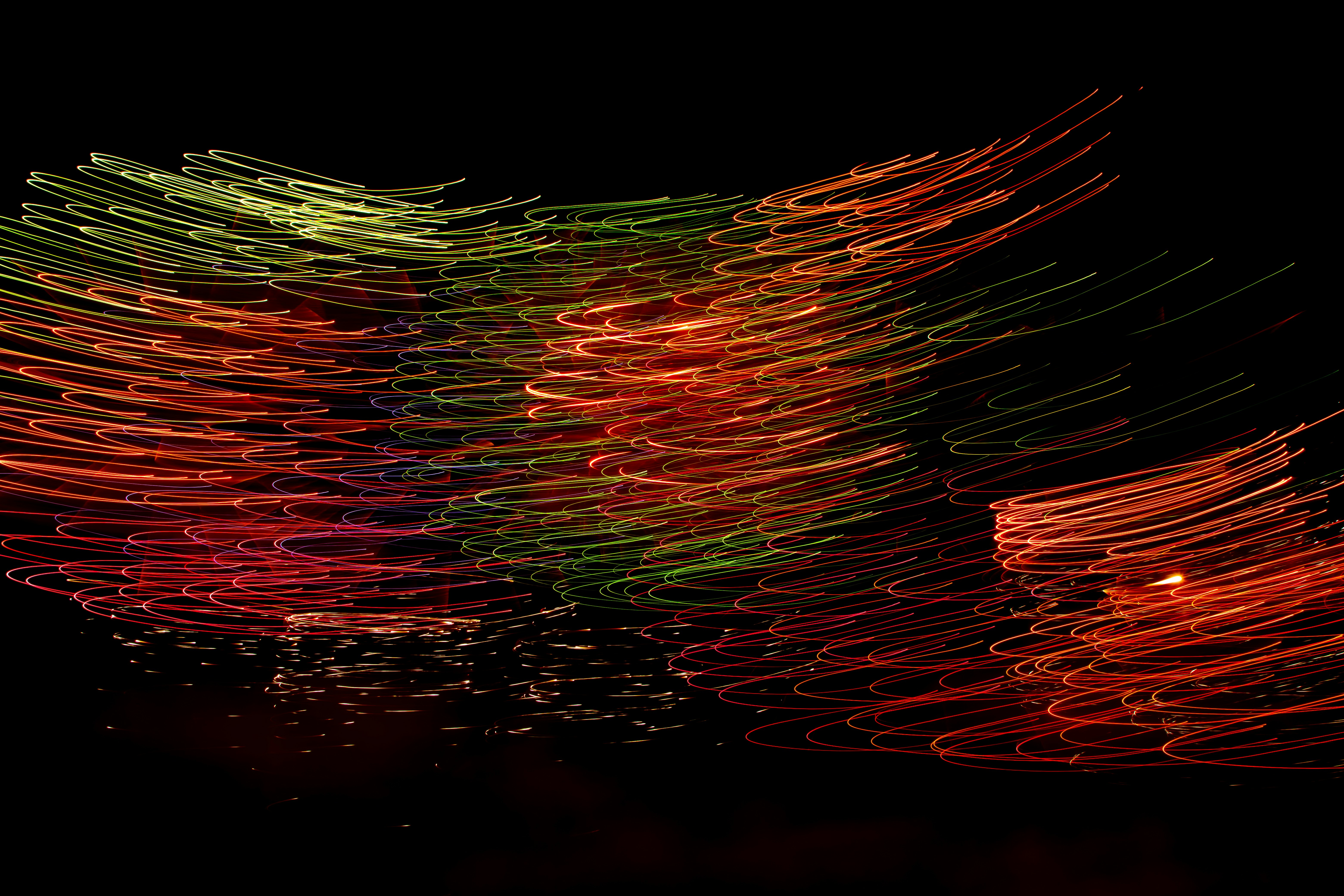 Colorful light trails swirl against a black background.