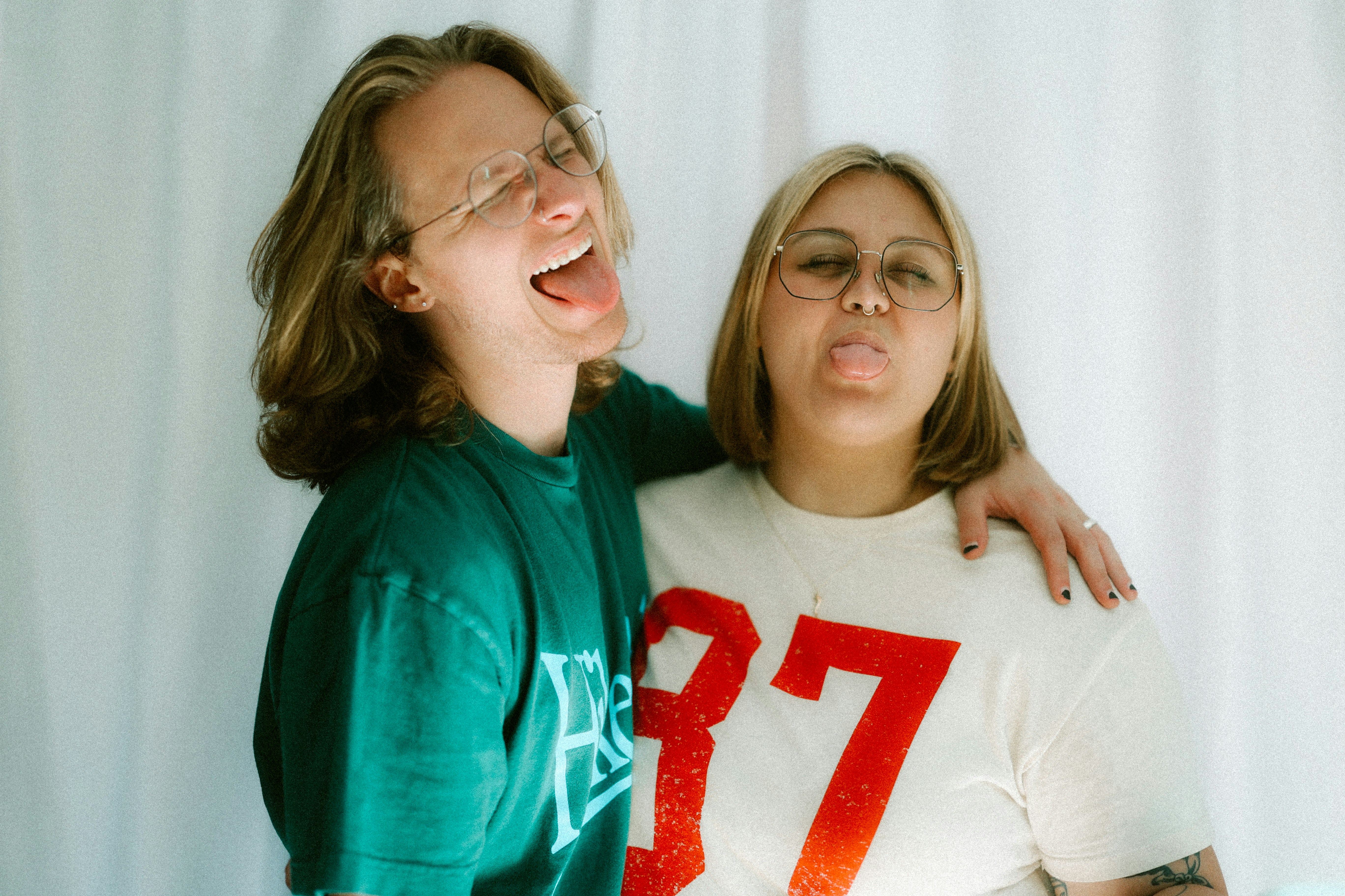 Two people are sticking their tongues out.