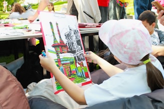 A young girl colorfully paints a picture.