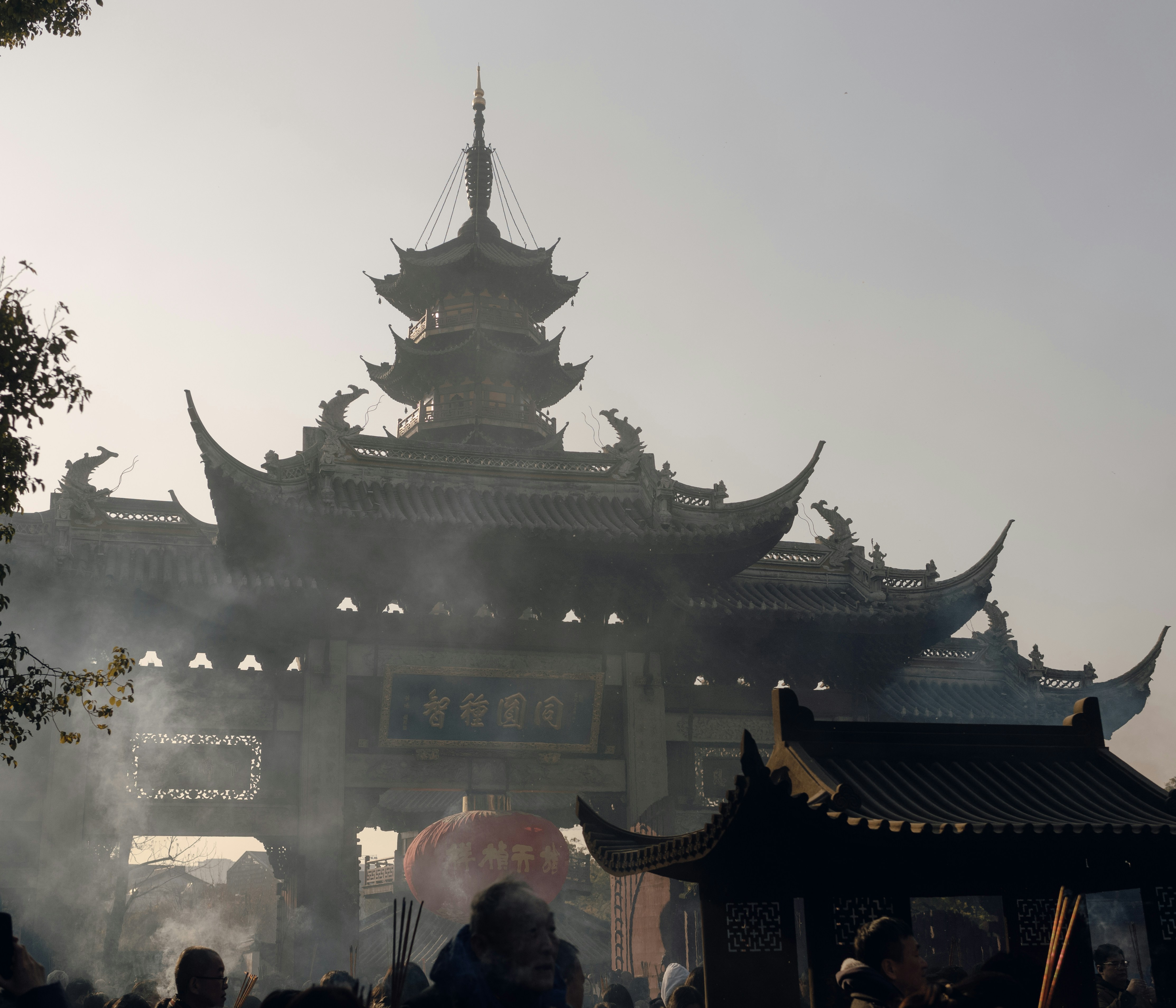A traditional asian temple is seen in the fog.