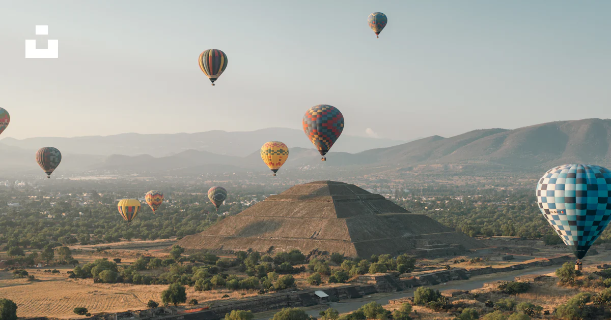 Hot air balloons fly over a pyramid landscape. photo – Free Pyramid ...