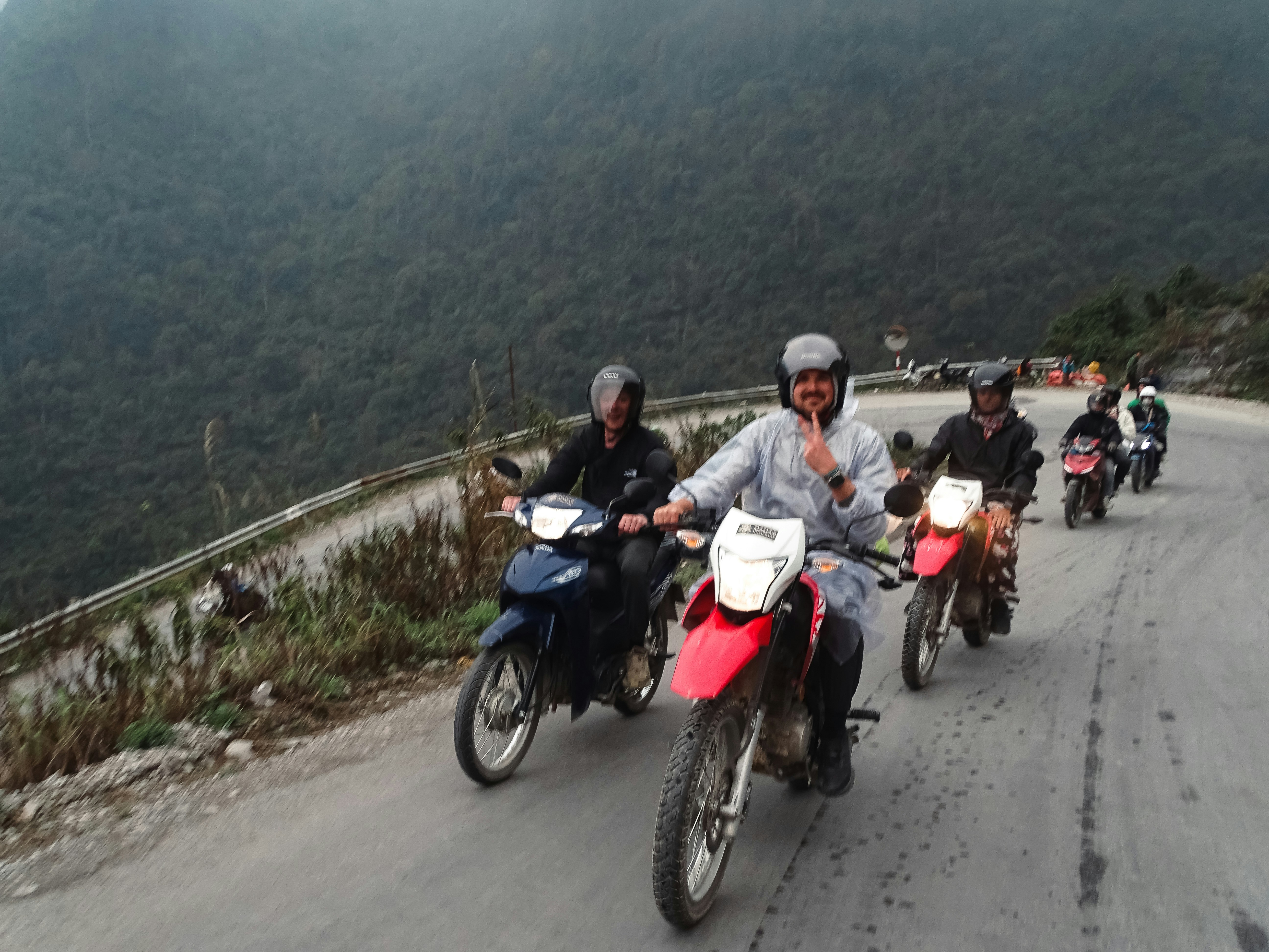 Menschen fahren mit dem Motorrad eine Bergstraße entlang.