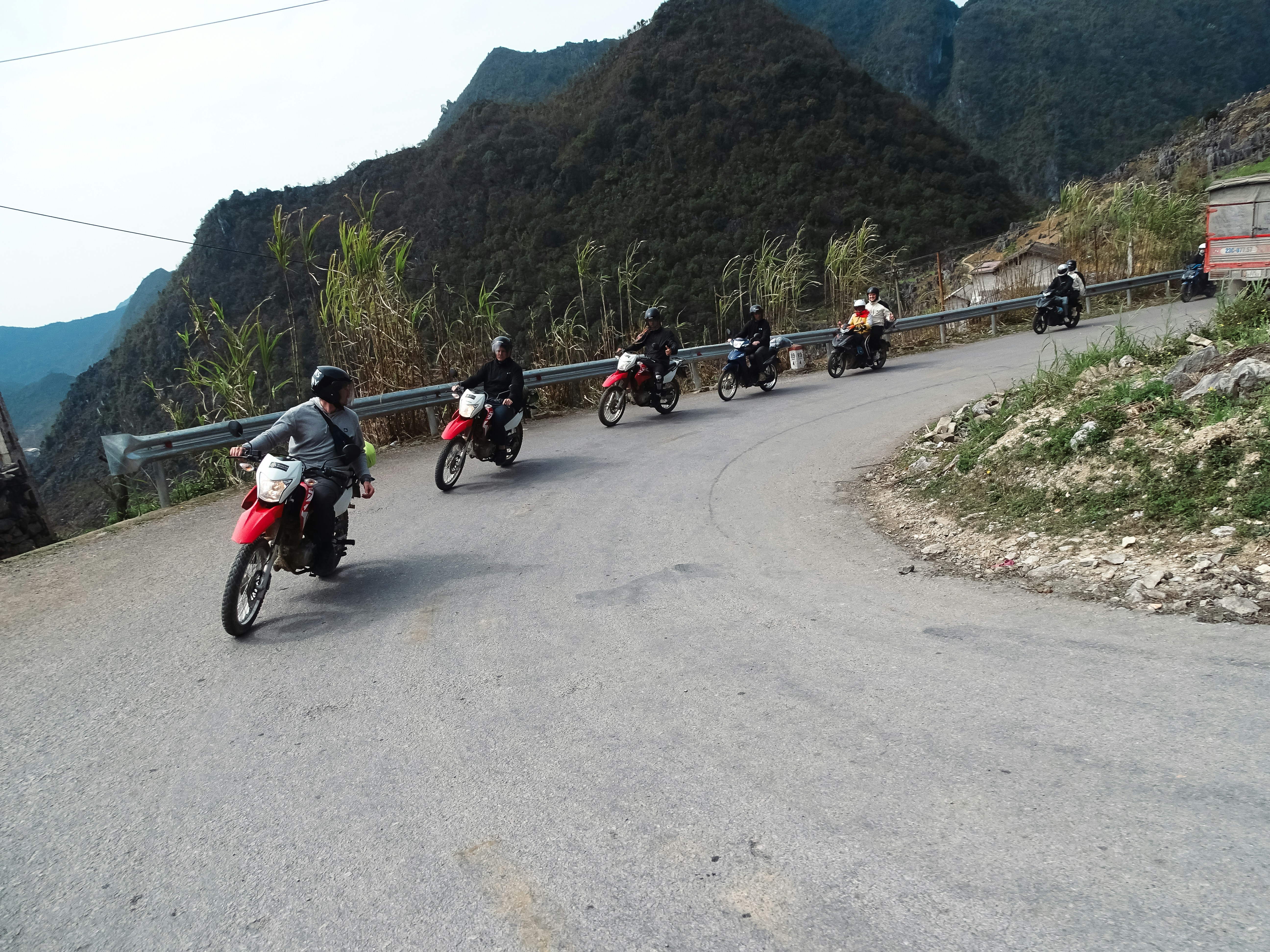 Motorradfahrer fahren auf einer kurvenreichen Straße in den Bergen.