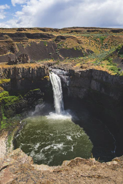 A powerful waterfall flows into a deep pool.