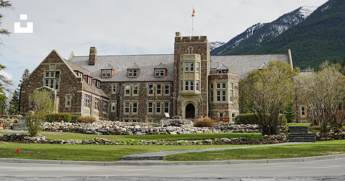 A stately stone building sits before a mountain. photo – Free Building ...