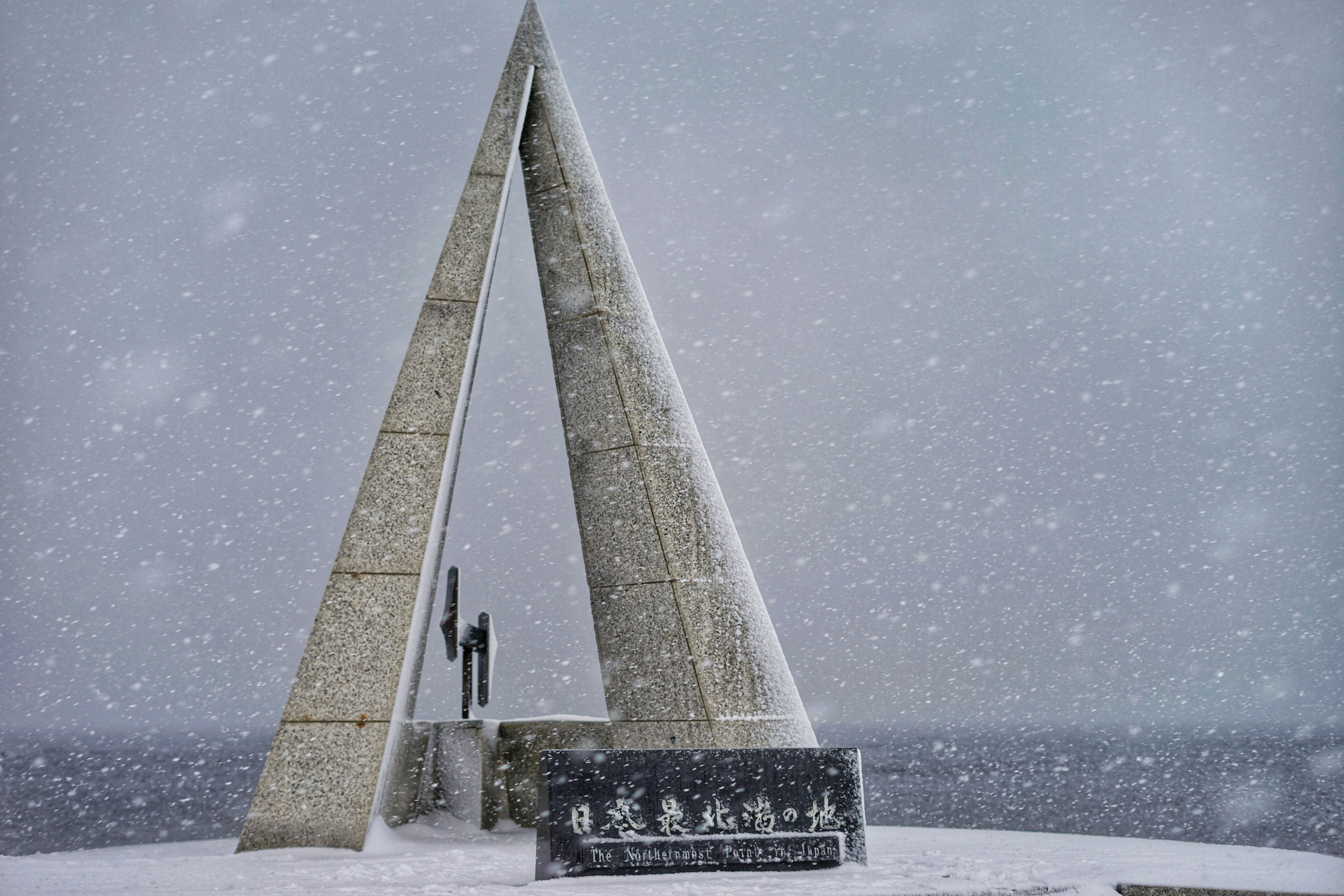 A monument stands tall in snowy conditions.