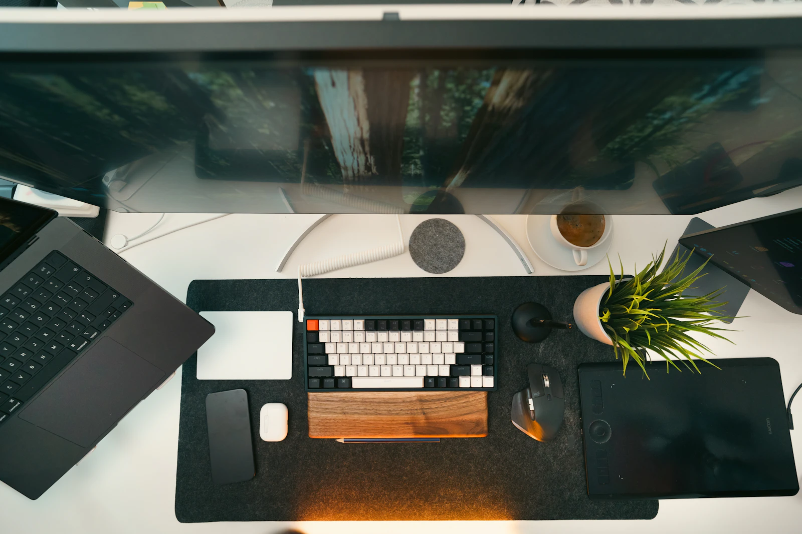 A tidy computer desk with a monitor, a laptop, a compact keyboard, and a mouse