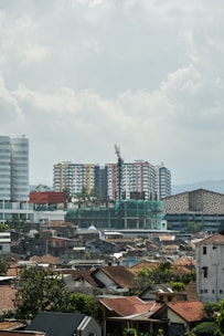 City skyline with various buildings under a cloudy sky.