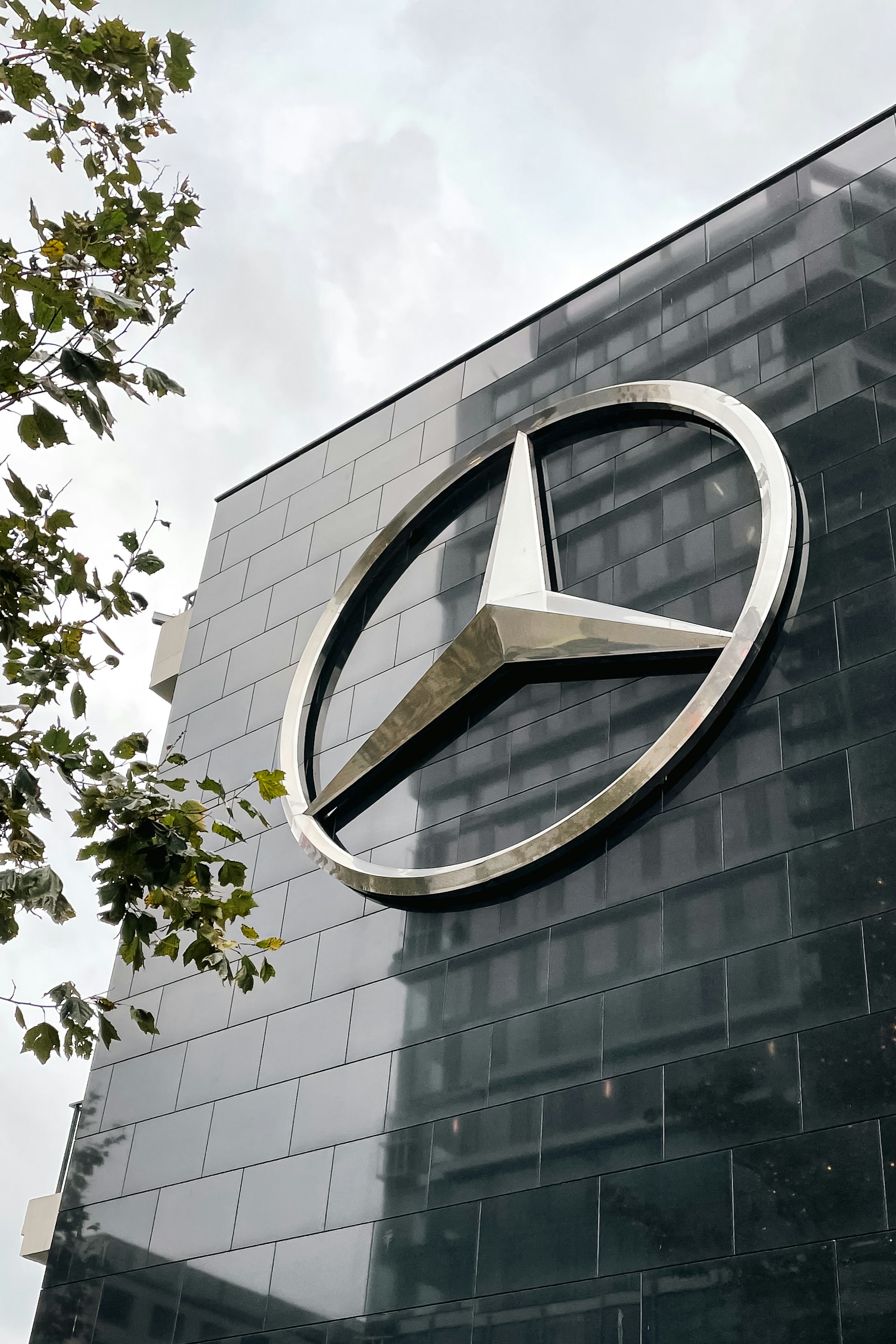 Mercedes-benz logo adorns a sleek, modern building.