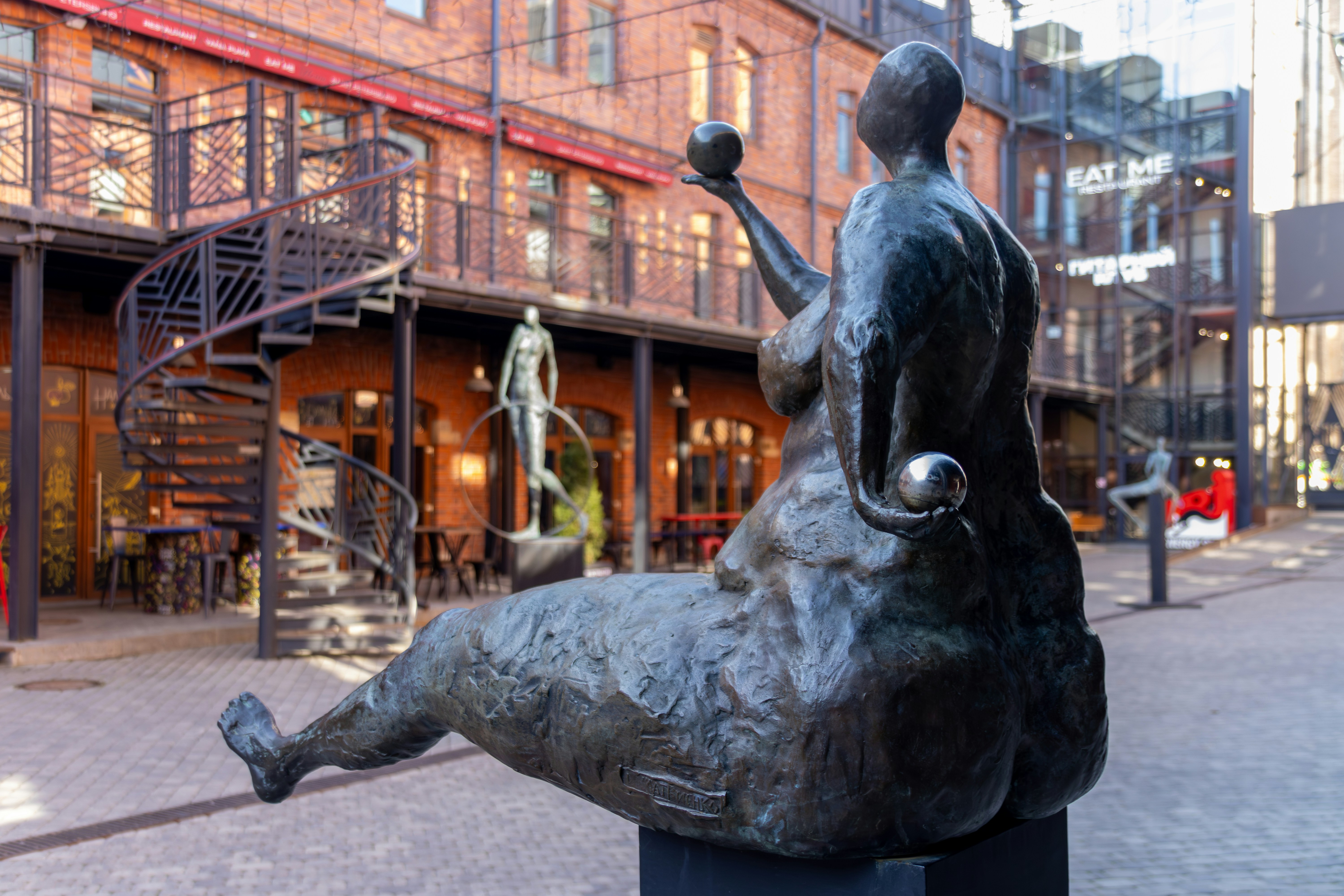 A bronze sculpture sits in an outdoor plaza.