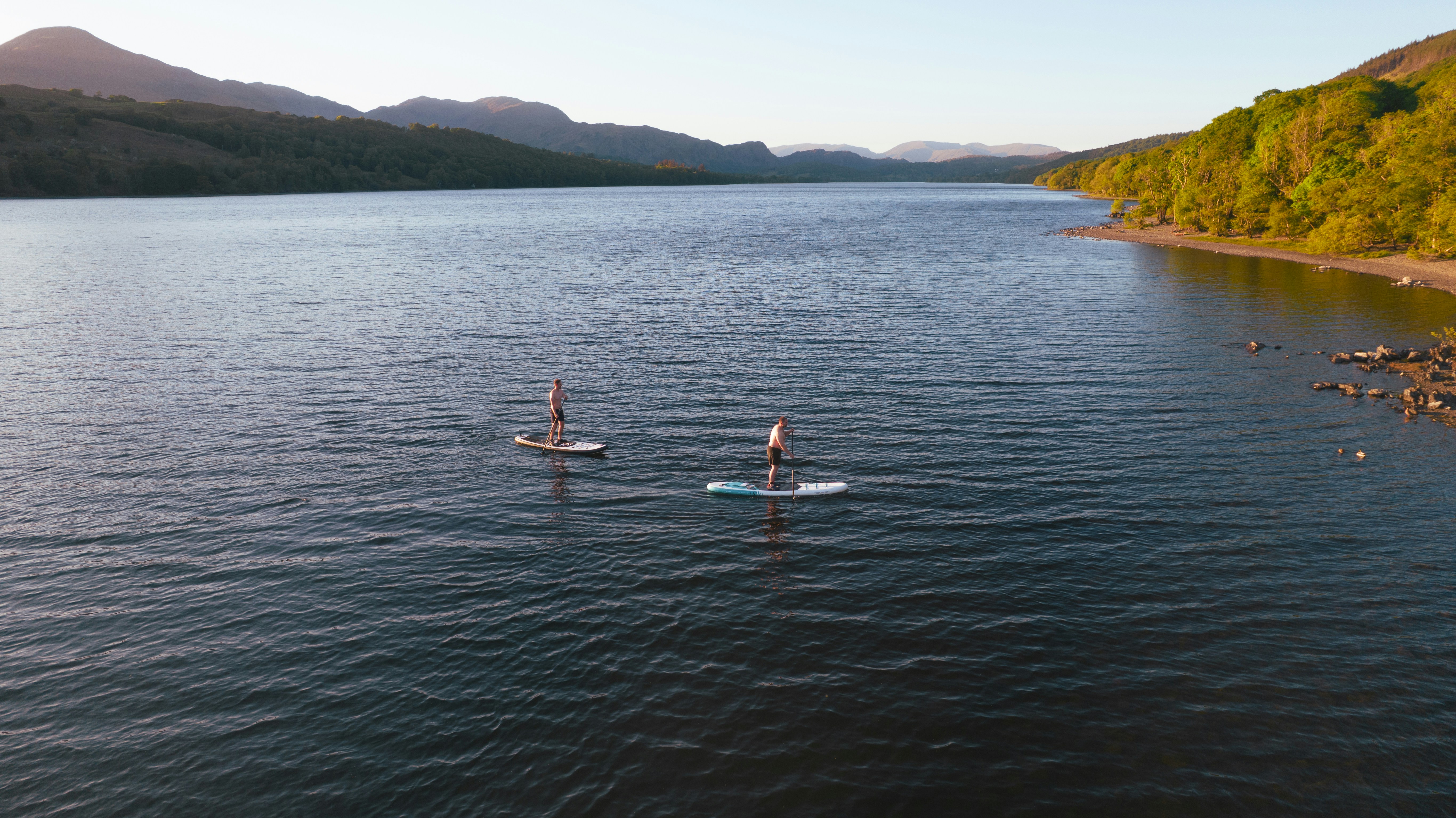 People paddleboarding on a calm lake.