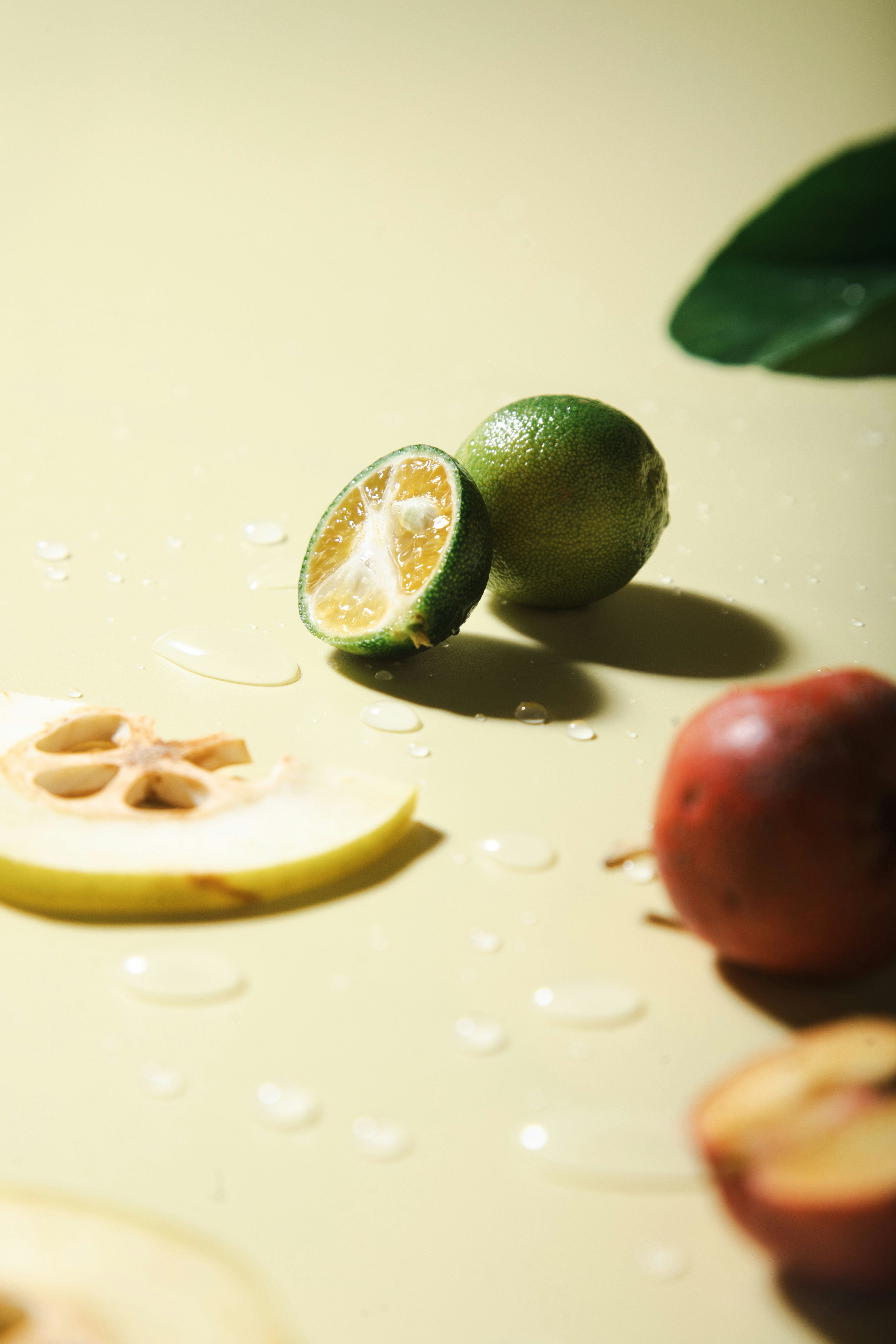 Fresh fruits and water droplets on yellow background.